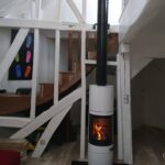 Poêle à bois Scan 83 blanc avec conduit départ appareil sous salon déplafonné de grande hauteur