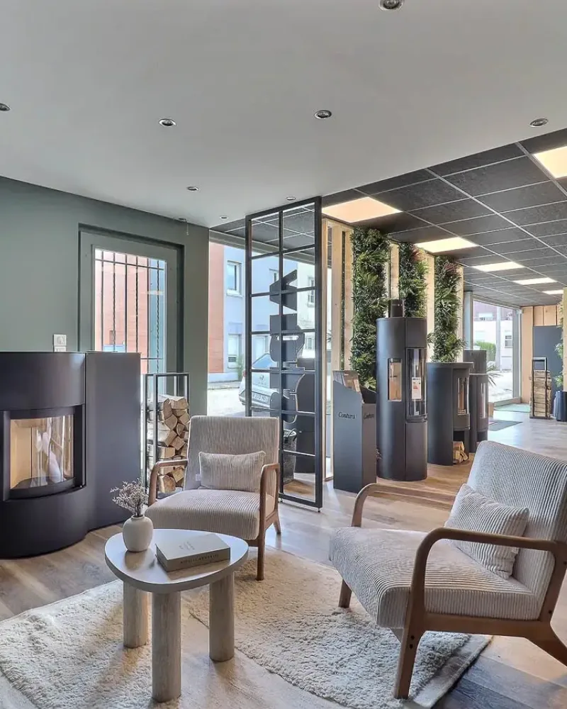 Showroom Origine à Bois-Guillaume : coin salon, fauteuils et poêles exposés